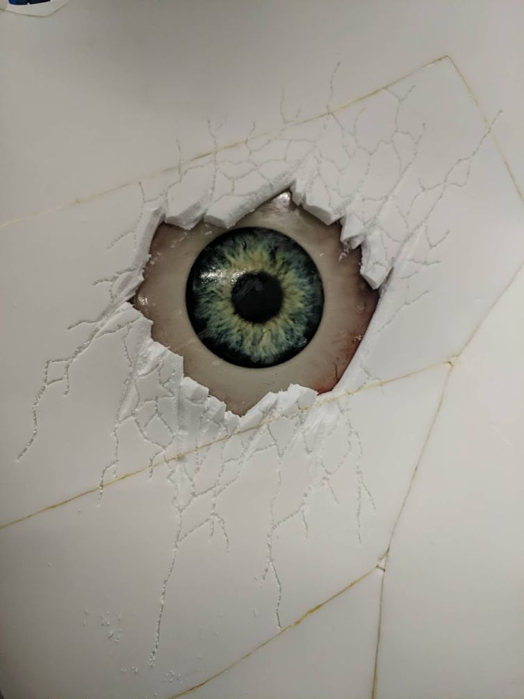 Giant resin eyeball behind cracked fabricated foam