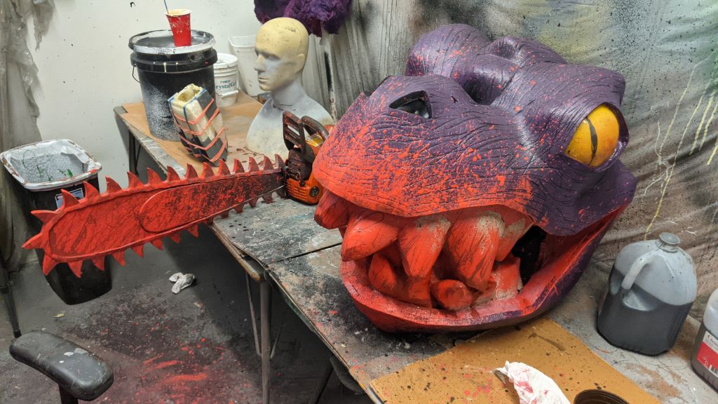 Bloodied T-Rex head and customized chainsaw prop