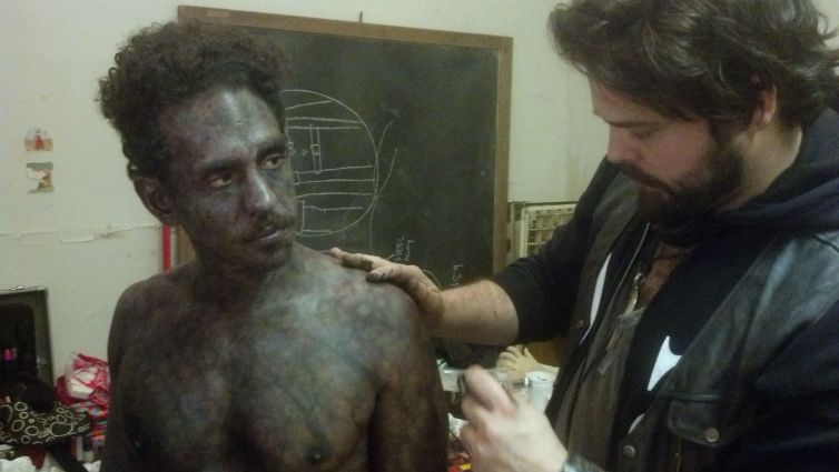 Director Tate Steinsiek does final looks on actor Ray Santiago's corpse makeup