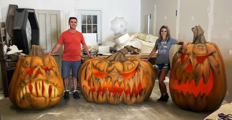 Happy customers pickup up giant jack-o-lanterns