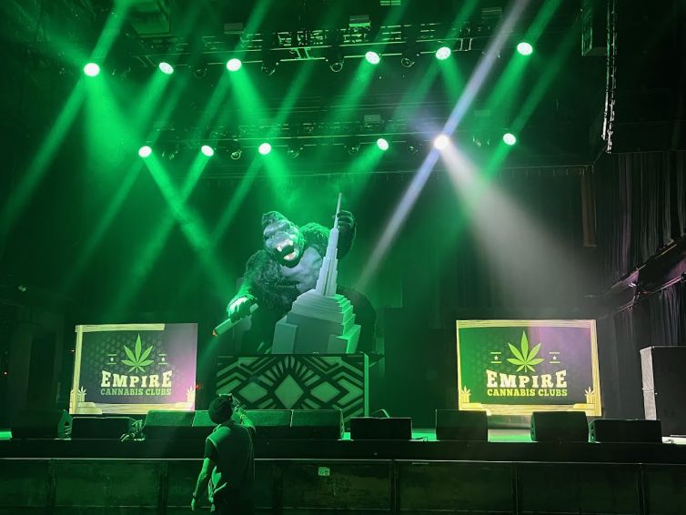 Empire Cannabis Clubs Kong smoking joint on stage getting ready for Method and Red