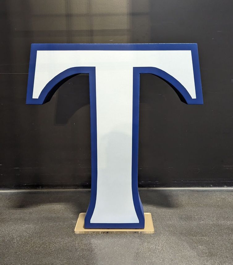 Trinity College "T" photo-op display painted in school colors of blue and white and attached to acrylic base