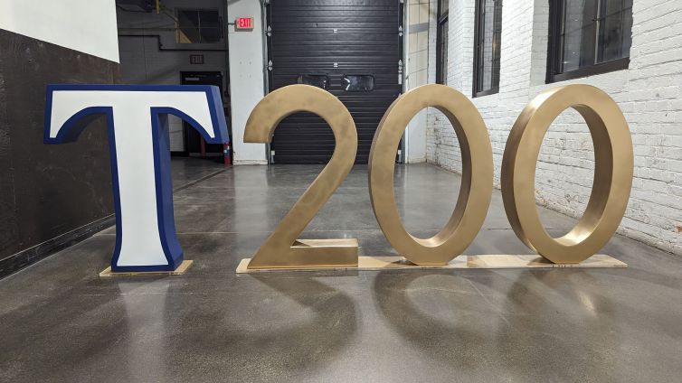 Completed large blue and white "T" and golden "200" photo-op displays attached to acrylic bases for Trinity College event