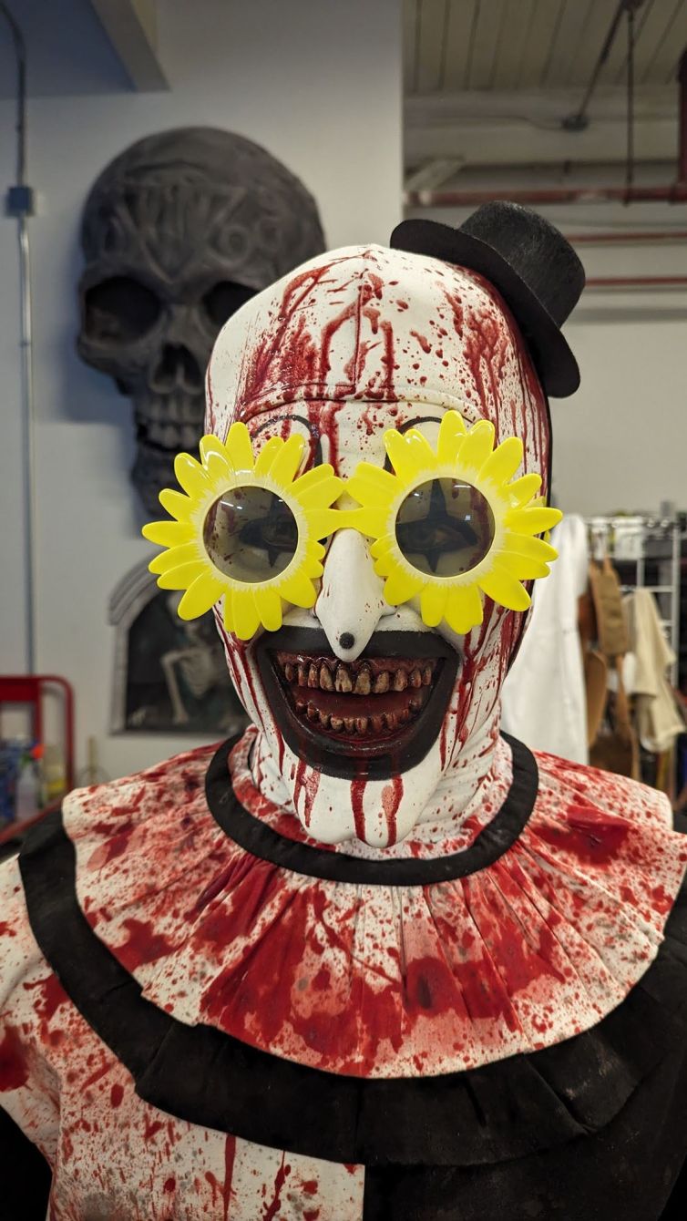 Art the Clown from Terrifier display, bloody clown mask, hat, and collar ruffle with optional sunflower sunglasses