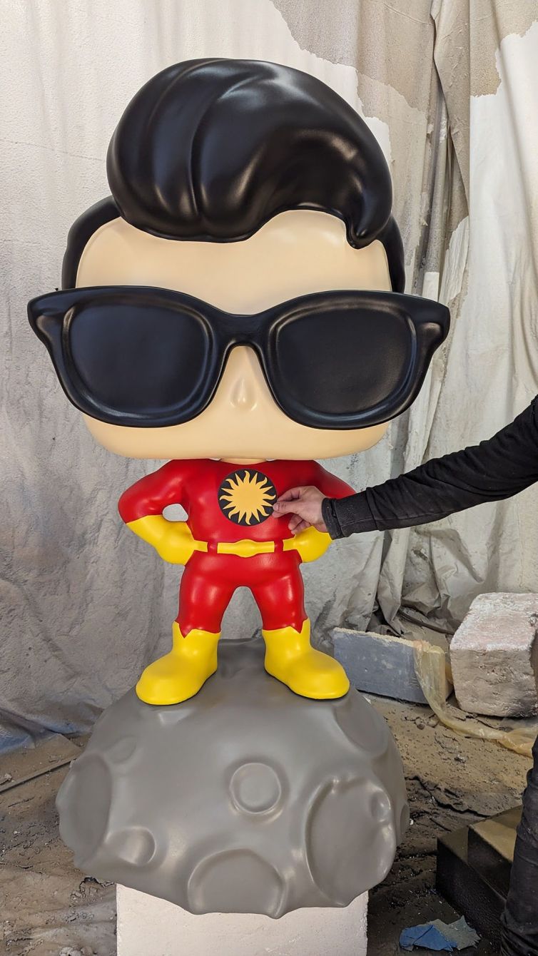 Gloss coat and testing chest logo on Captain TerrifiCon Funko Pop style photo-op statue with glasses and asteroid moon base