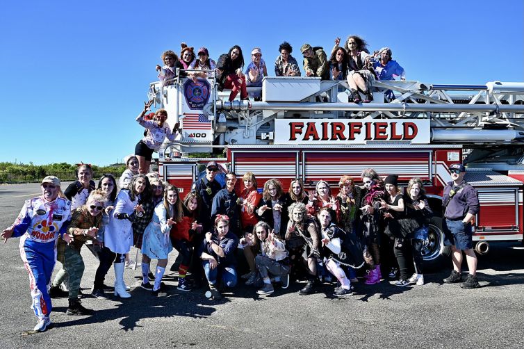 MOMbie group photo with Fairfield Fire Department in front of and on top of fire truck