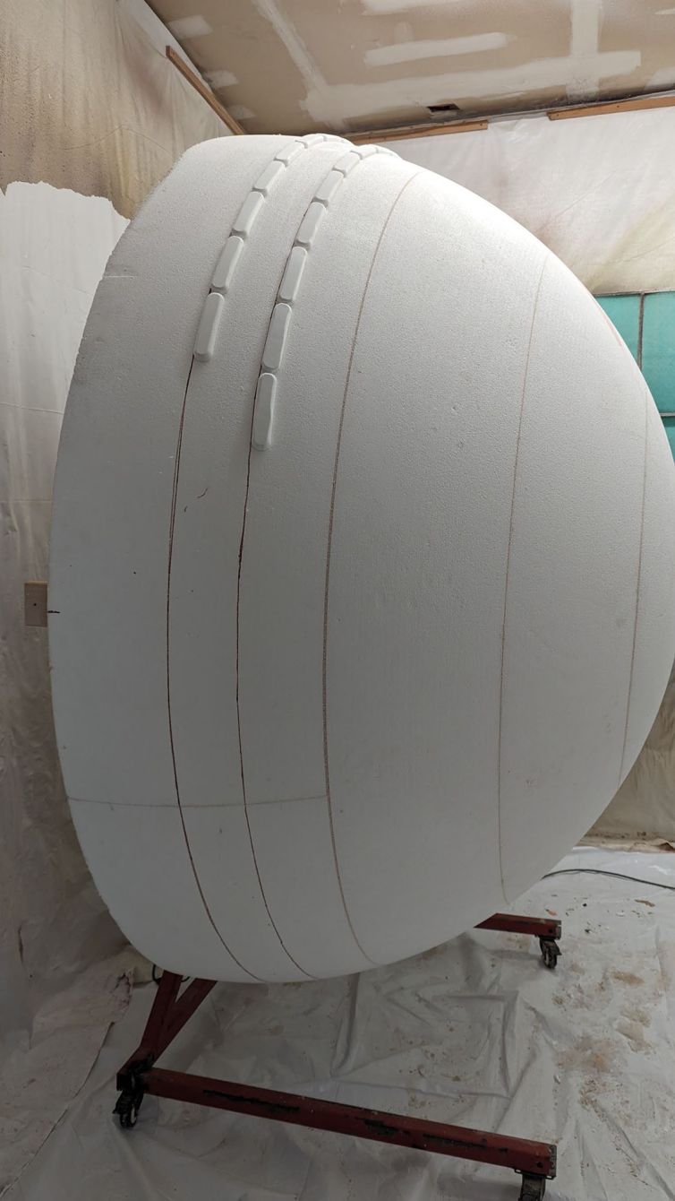 Attaching the stitching strands to the outside of the styrofoam ball while attached to the spinner