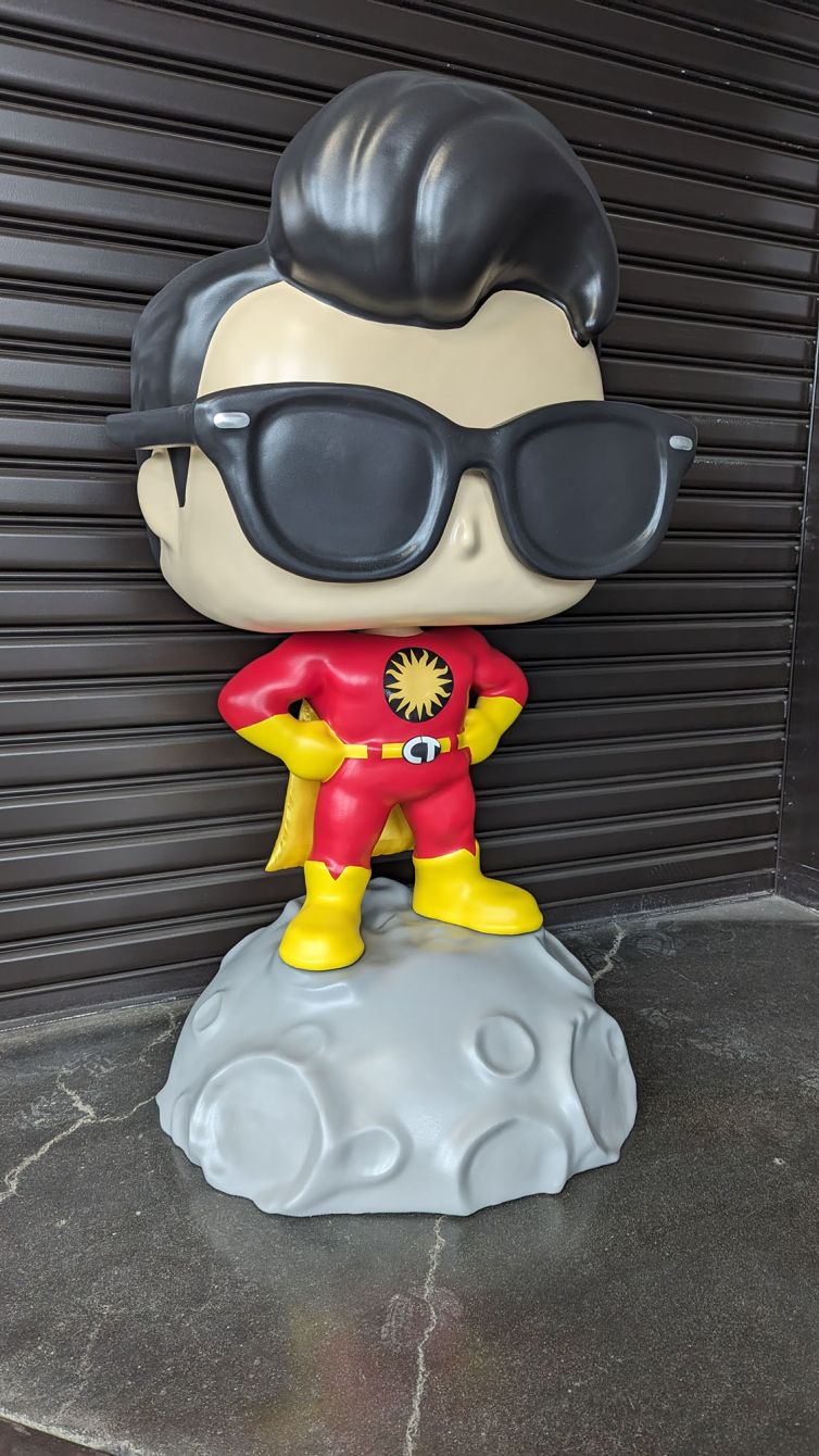 Right side of the Captain TerrifiCon Funko Pop style photo-op statue with swoop hair, glasses 3D printed belt buckle, and asteroid moon base