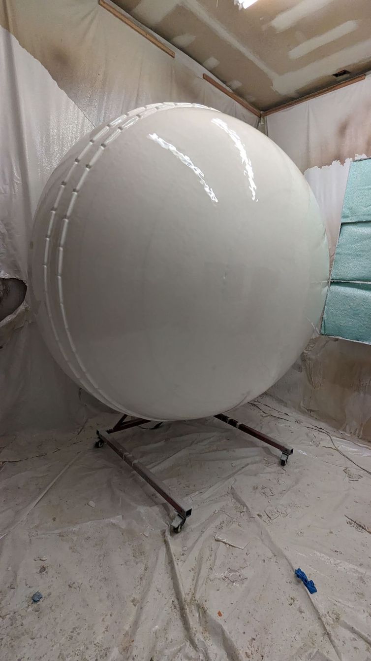 Hard-coating the styrofoam ball with stitching on the spinner stand to get a glossy smooth finish