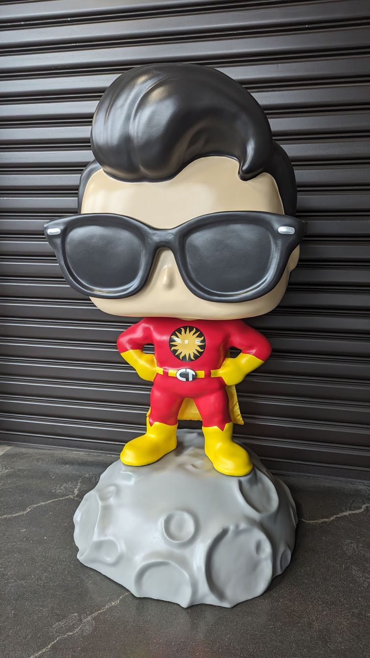 Left side of the Captain TerrifiCon Funko Pop style photo-op statue with swoop hair, glasses 3D printed belt buckle, and asteroid moon base