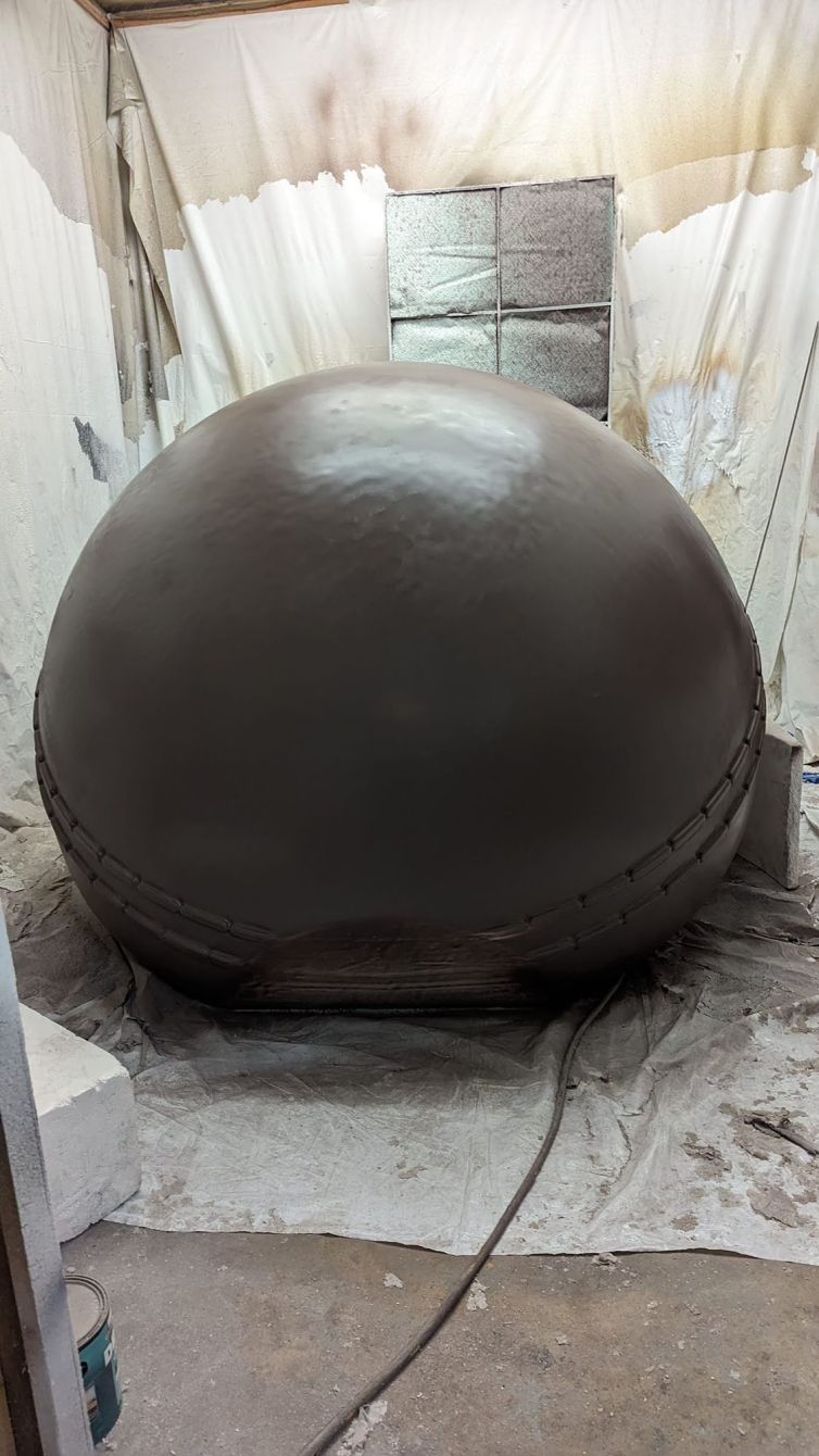 Primer coating the hard-coated styrofoam ball halves in a dark shade to fix imperfections