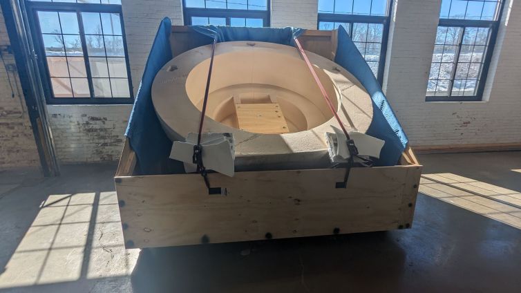 Cricket ball half strapped down into shipping container and ready to go out